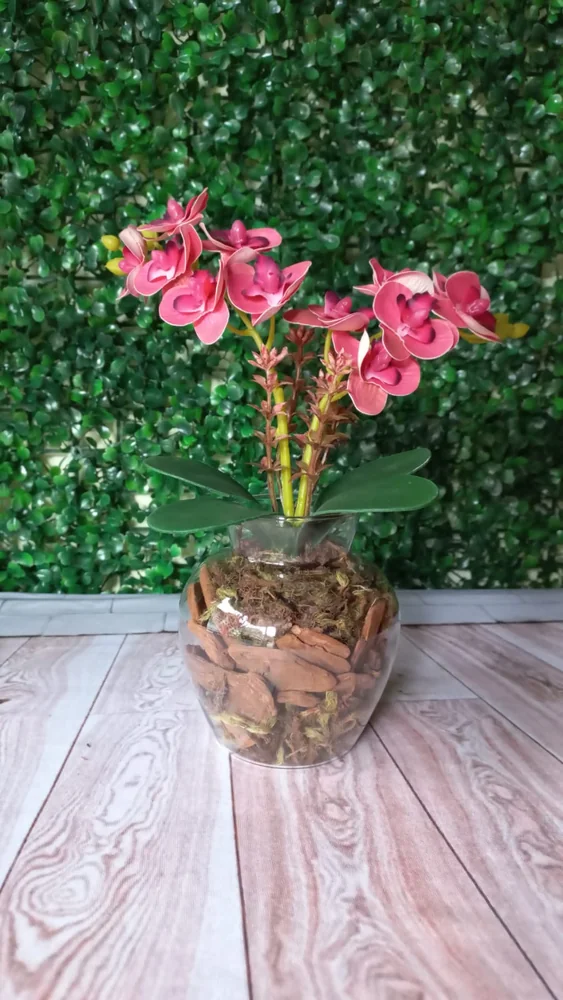 Arranjo de orquídeas rosa em vaso redondo de vidro